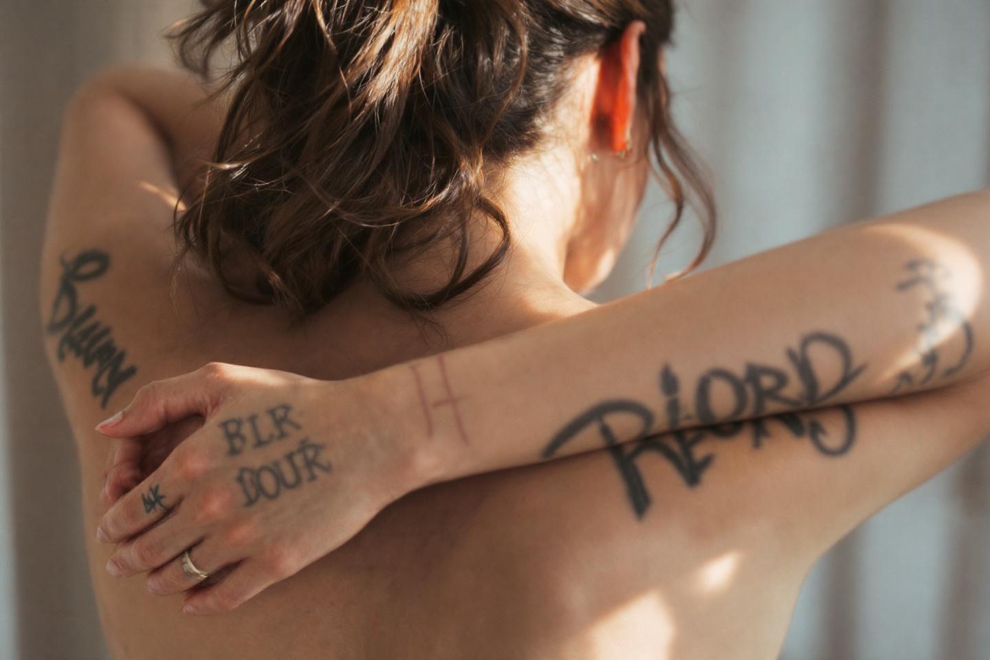 Bras tatou&eacute;s avec des &eacute;critures artistiques et &eacute;l&eacute;gantes